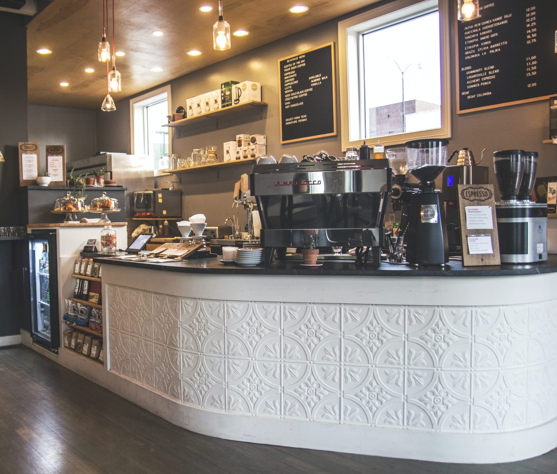 Inside a coffee shop, a polished counter and a stylish bar area are showcased, inviting patrons to enjoy their favorite beverages.